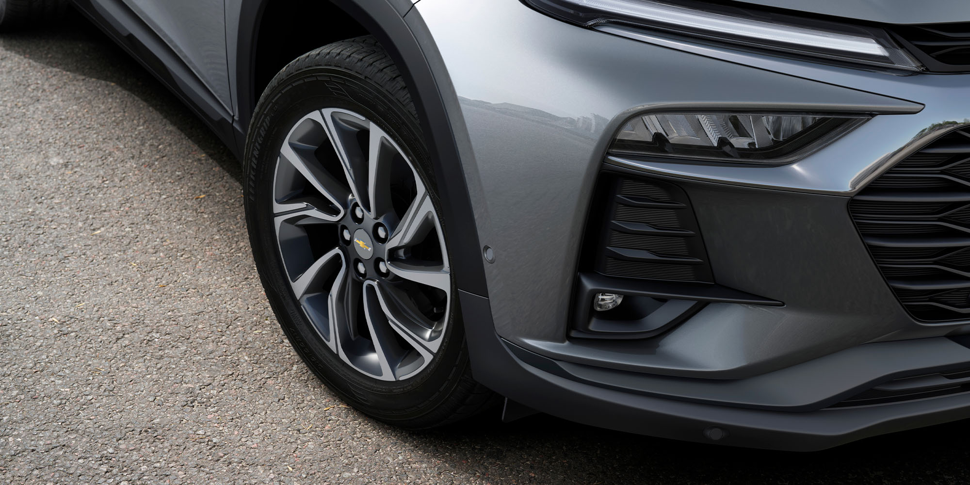 Detalle de rin y parte frontal de Chevrolet Tracker color gris